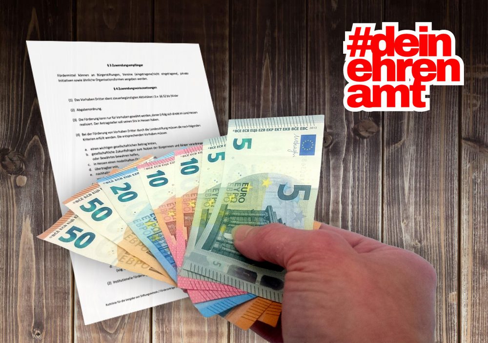 Geld und ein Förderantrag auf einer Bretterwand
